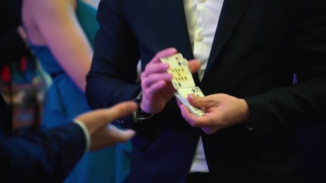 Professional croupier during cards shuffle in the casino