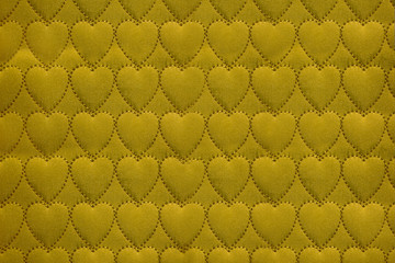 Abstract heart background on textiles, fabric stitched heart symbols Golden ochre color. Handmade