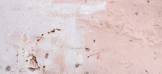 Old weathered painted wall background texture. White dirty peeled plaster wall with falling off flakes of paint.