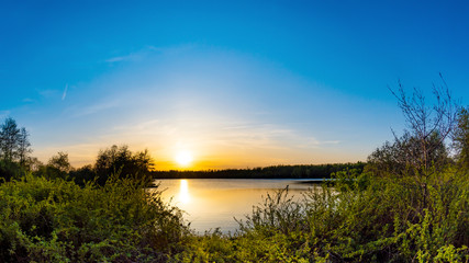 Naklejka na ściany i meble Lake with trees at sunset on a beautiful summer evening
