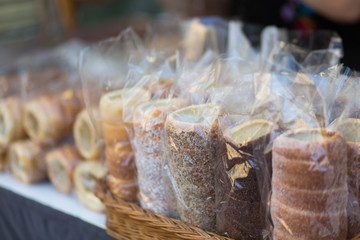Fresh Kürtőskalács sale in Budapest.  Several Trdelník sold in a basket on the counter. Trdelnik or Kurtoshkalach