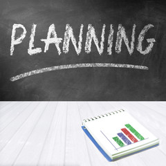 Chalkboard with the word planning written on. Notebook with financial graph. Business concept.