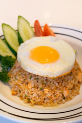 Salmon garlic fried rice with fried egg and tomato,cucumber.