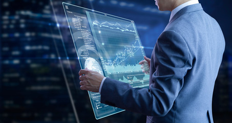 Businessman holding a modern tablet touch screen analysing on investment risk management and return...