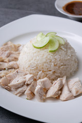 Hainanese chicken rice or rice cooked in chicken broth in the white dish.