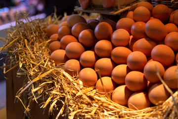 Basket with big natural ecological farm chicken eggs on the hay with warm light