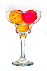 Pickleball Cocktail with colorful Pickleballs in a Margarita glass with a white background