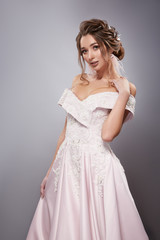 gorgeous bride touching her shoulder in white fancy dress