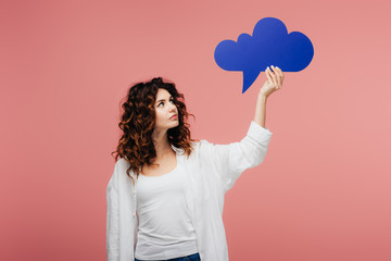 attractive curly girl with red hair looking at blue thought bubble on pink