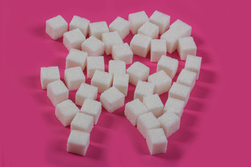 Sugar destroys the tooth enamel and leads to tooth decay. Sugar cubes are laid out in the form of a tooth and cavity
