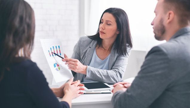Professional woman broker giving presentation to young couple