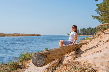 Portrait of smiling young woman laying on sea coast