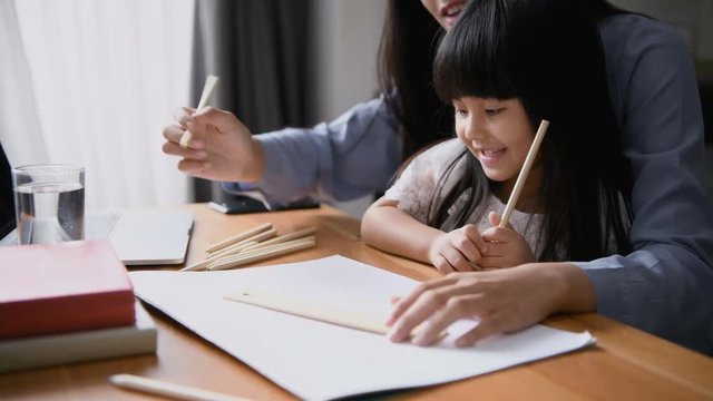 Family concept. Mom is teaching children to draw pictures.
