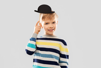 party props, photo booth and childhood concept - smiling little boy with black vintage bowler hat...