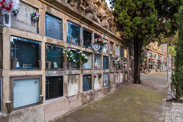 Perspective view of the footpath with graves on the Montjuic Cemetery in overcast day, Barcelona, Catalonia, Spain