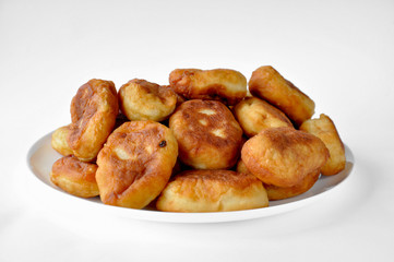 large white plate with fried pies with filling on the table on a white background