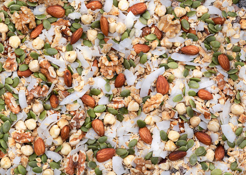 Mixture of dried coconut, pepita seeds and nuts; background.