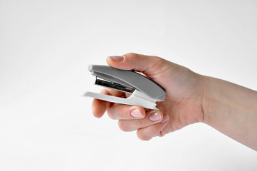 gray stapler in his right hand on a white background