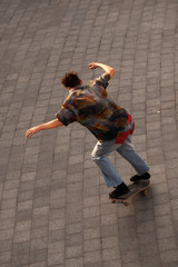 Fototapeta na wymiar Young guys in stylish clothes ride a skateboard in the park.