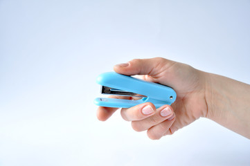 blue stapler in his right hand on a white background