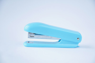 blue stapler stands on table on white background