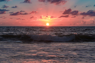 pink sunrise over the wavy ocean