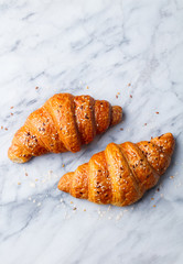 Croissants on marble table. French traditional pastry. Top view. Copy space.