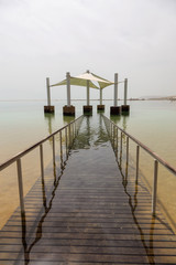 Obraz premium Path leading into the water on a sandy beach at the Dead Sea during a sunny day. Taken in Ein Bokek, Israel.