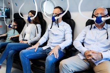 Group of mixed age patients with oxygen masks in hyperbaric chamber.