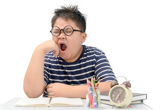 Student boy with glasses yawning on the table i - Powered by Adobe