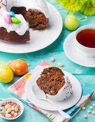 Easter cake on a white plate with colorful eggs. Blue wooden background.