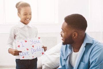 Daughter congratulating dad with father's day at home