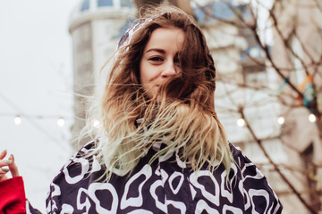 Portrait of a young beautiful woman in a raincoat, walking and dancing in the rain