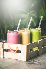 Fresh smoothies on tropical background, close up
