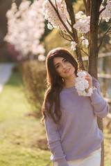 Beautiful girl stand by white blooming three