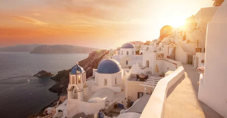 Tuinposter The famous three blue domes in Santorini at sunset © Cara-Foto