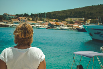 Fototapeta na wymiar Young woman standing on a beach and enjoying the sun in Lefkada island, Greece