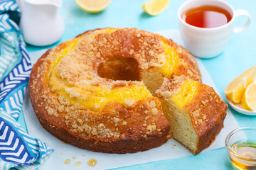 Lemon bundt cake with cup of tea. Blue background. Close up.