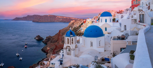 The famous three blue domes in Santorini at sunset