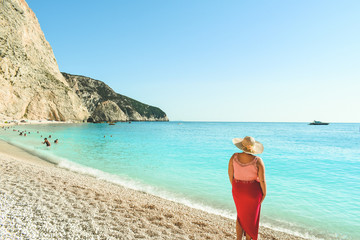 Young woman standing on a beach and enjoying the sun in Lefkada island, Greece