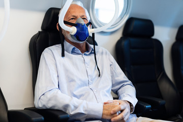 Senior man having oxygen therapy in hyperbaric chamber.