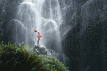 Tänzerin posiert vor Wasserfall