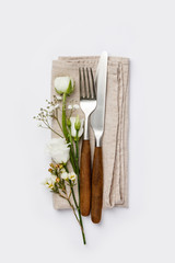 Flowers with fork and knife on white background