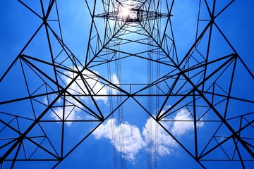 Silhouette ant eyes view of high voltage tower with power lines against cloud and blue clear sky background in sunny day, technology concept