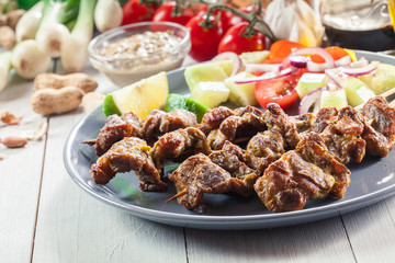 Traditional pork satay with peanut sauce and vegetables