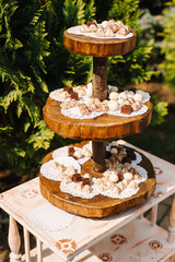 Wooden candy bar at outdoor wedding celebration, catering table in rustic style