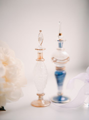 Beautiful vintage bottles of perfume on white table with flowers. Beauty and care  concept