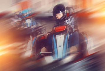 Female racer in helmet driving kart on track - obrazy, fototapety, plakaty