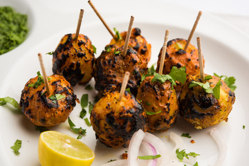 Tandoori aloo are roasted potatoes with Indian spices. It's a party appetiser served with green chutney. selective focus