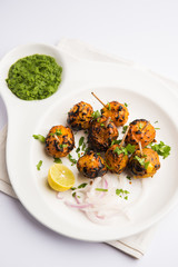 Tandoori aloo are roasted potatoes with Indian spices. It's a party appetiser served with green chutney. selective focus